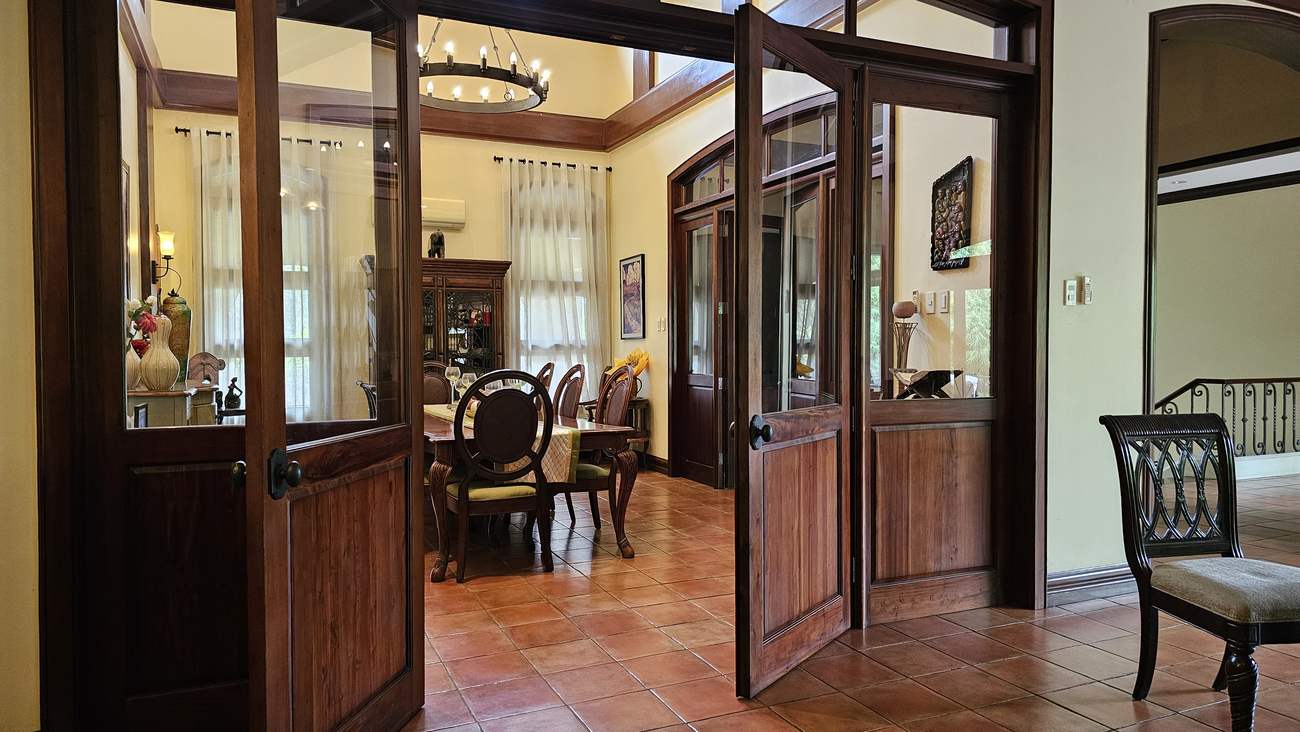 Premium hardwood and glass French doors opening from the hall into the vaulted dining room of this luxury Mandaue City home