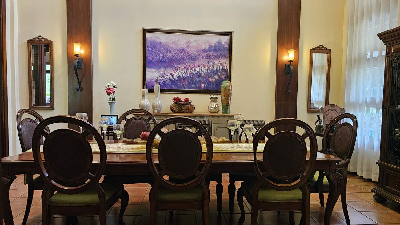 High-end dining table for ten with wall sconces, mirrors and framed artwork